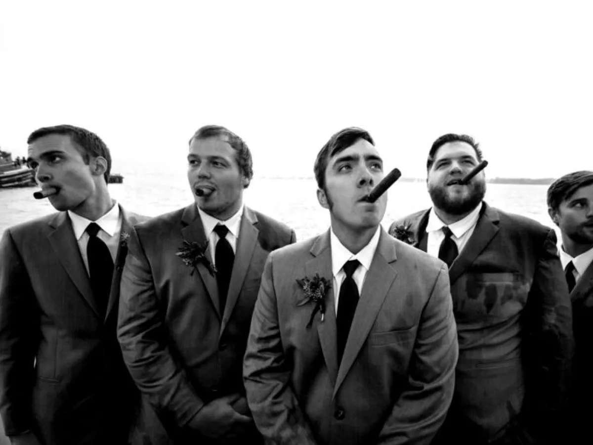 a group of men standing next to a body of water