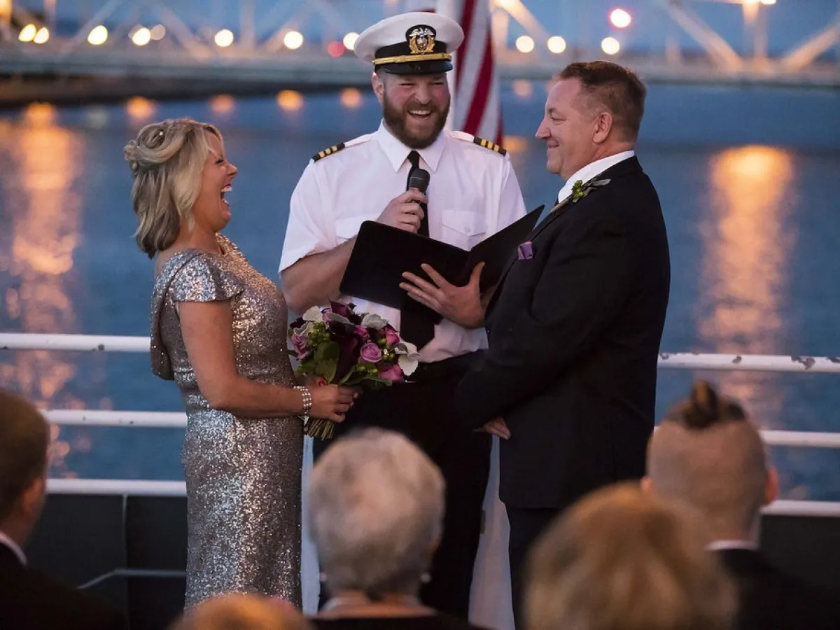 bride and groom with officiant in between them laughing
