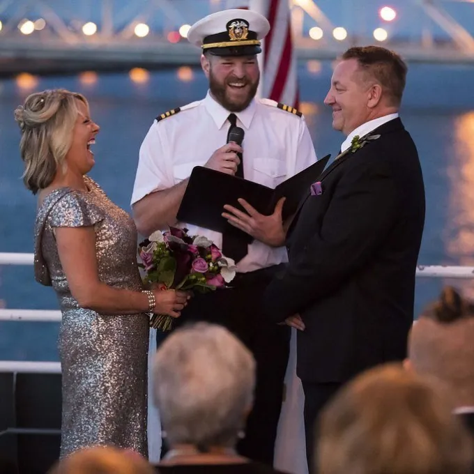 bride and groom with officiant in between them laughing