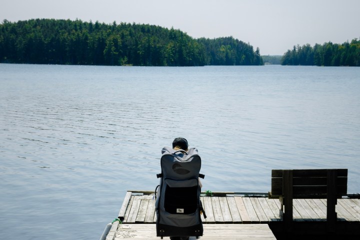 a man sitting on a dock next to a body of water