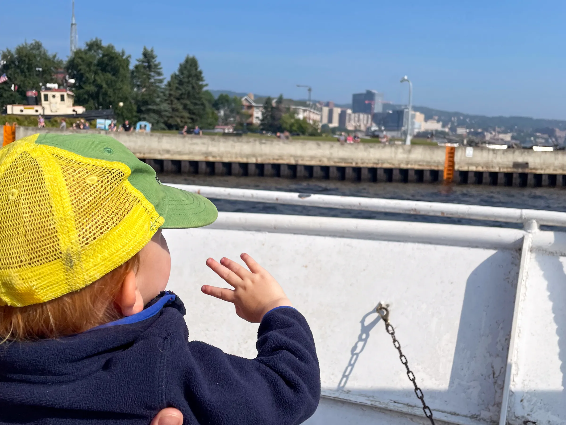 Little boy waving from a boat