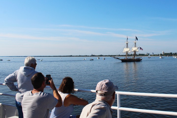 a group of people sitting on a dock next to a body of water