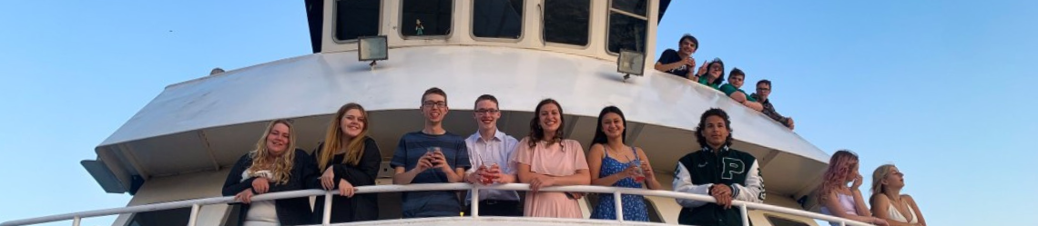Group of students smiling on a boat during prom