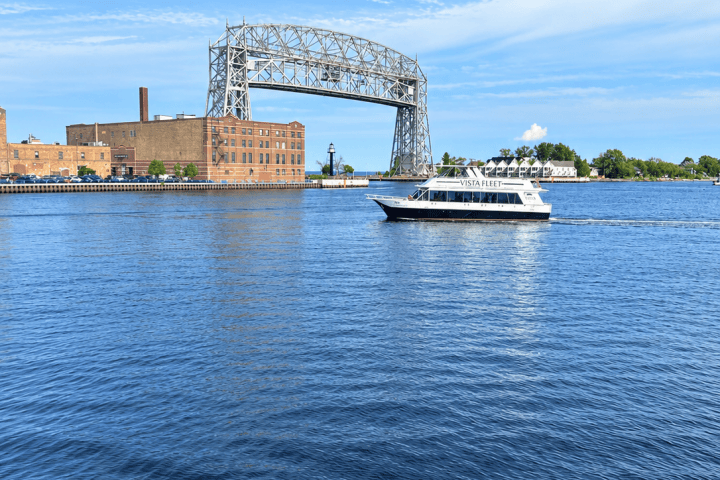 Vista Queen on Lake Superior near the Duluth Aerial Lift Bridge under a clear sky.